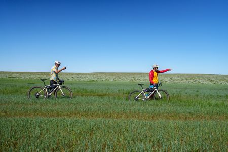 Tommy Caldwell and Alex Honnold pushing their bikes through marshland.  (National Geographic/Taylor Shaffer)