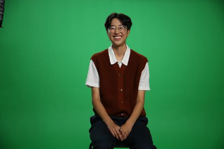 A-Bel Gong sitting and smiling Infront of green screen. (National Geographic/Robert Toth)