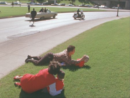 Bill and Gayle Newman cover their children, Clayton and Billy, laying down on the grass immediately following the assassination of President John F. Kennedy in Dallas, Nov. 22, 1963. (John F. Kennedy Presidential Library and Museum, Boston)