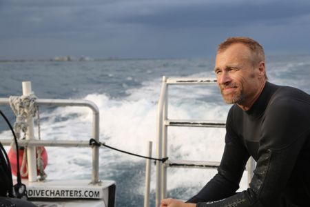 Mike Heithaus sitting on the Calypso Dive Charter boat prior to his dive for the shark hearing test. (National Geographic/Tristan Goodley)