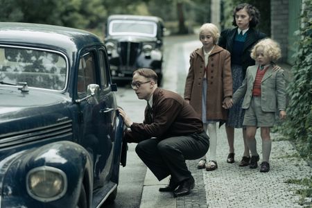 A SMALL LIGHT - Jan Gies, played by Joe Cole, searches for a car key while Liddy, played by Audrey Katan, Miep, played by Bel Powley, and Alfred, played by George Cobell, look on in A SMALL LIGHT. (Credit: National Geographic for Disney/Dusan Martincek)