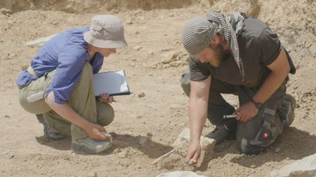 Jan Heiler and Ulrike Buerger carefully remove dirt at the dig site in Mosul, Iraq. (Windfall Films/Ali Hilal Ali Hussain)