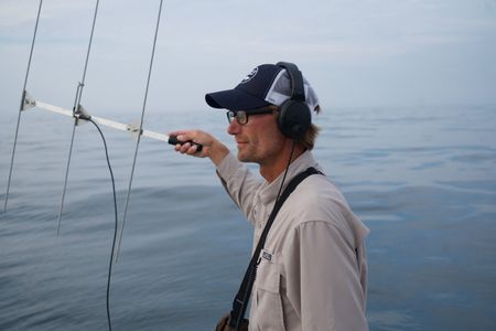 Capt. Greg Metzger uses a VHF receiver on the boat, as the team desperately try to get a signal from Liberty's tag. (National Geographic/Brandon Sargeant)
