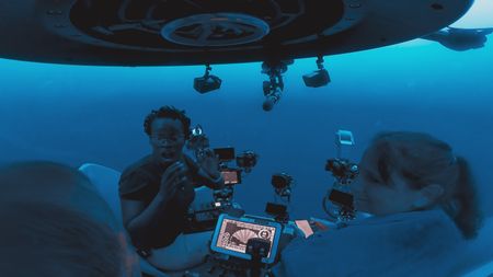 Submersible pilot Buck Taylor, Zoleka Filander and Mithriel Mackay descend in one of the OceanXplorers submersibles on the way down to test the hypothesis that male humpback whales use the topography of the island to acoustically enhance their songs. (National Geographic)