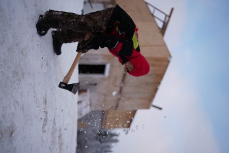 Wade Kelly cuts through the frozen ground with his axe.(BBC Studios Reality Productions, LLC/Ashton Hurlburt)