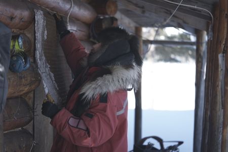 Ricko DeWilde bear proofs his cabin before he leaves for the remainder of the season. (BBC Studios Reality Productions, LLC/JR Masters)