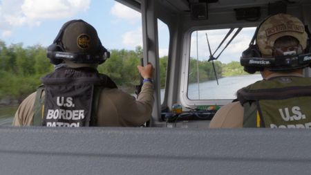 Two Border Patrol agents patroll on a boat looking for suspicious behavior on the Rio Grande River in the Rio Grande Valley, Texas. (National Geographic)