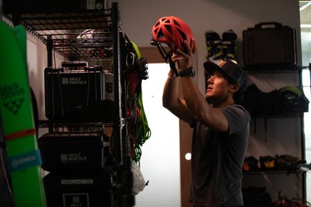 Filmmaker Jimmy Chin returns a helmet to his gear rack.  (photo credit: National Geographic/Teague Wasserman)