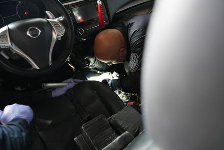 CBP Officers Torres and Ramirez work together to access smuggled contraband hidden inside of a suspect's vehicle in Brownsville, Texas. (National Geographic)