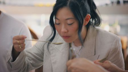 Awkwafina tastes the seaweed soup at Mrs. Kwon's. (National Geographic)