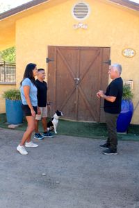Fernando holding Romeo on a leash next to Nicole while talking with Cesar. (National Geographic)