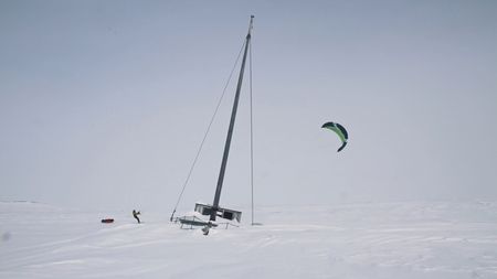 Sarah McNair Landry kite skiing past a boat buried in snow.  (Mandatory photo credit: Sarah McNair Landry)