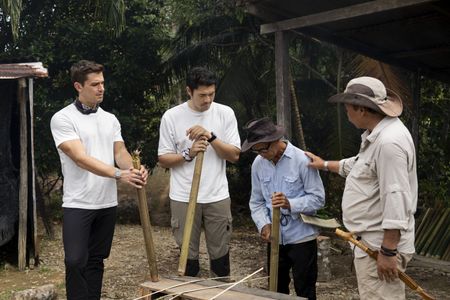 Antoni Porowski, Henry Golding, Abang Anak Engkamat and Nicholas Duda Anak Gardi cut bamboo at Pematoh Longhouse. (National Geographic/Rebecca Eishow)