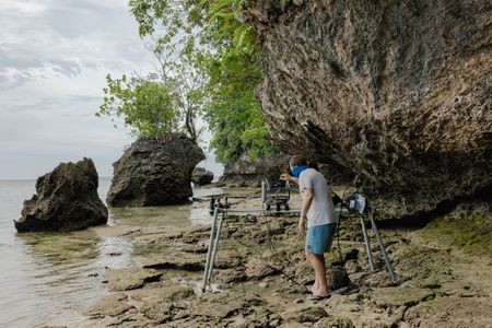 Camera assistant, Woody Spark, setting up a special remote system to film the landscape of the Lembeh Strait.   (photo credit: National Geographic/Harriet Spark)