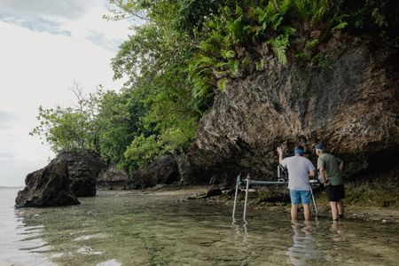 Camera assistant, Woody Spark, and cinematographer, Rory McGuinness, operating the remote slider system to film the landscape on the Lembeh Strait.  (photo credit: National Geographic/Harriet Spark)