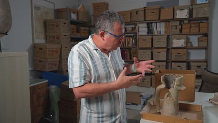 Dr. Guy Stieble explains the use of an amphora excavated at Masada, Israel. (Windfall Films)