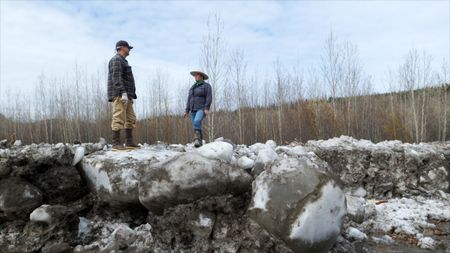 Jody Potts-Joseph and her husband Jamey Joseph look at the Yukon River spring break-up damage caused by the ice. (National Geographic)