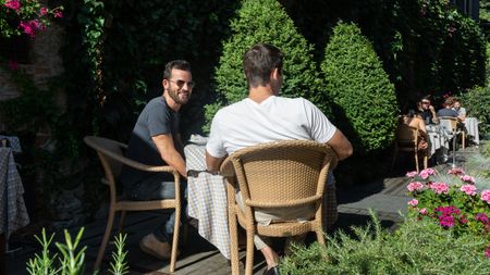 Justin Theroux and Antoni Porowski dine at Locanda del Falco's courtyard. (National Geographic/Rebecca Eishow)