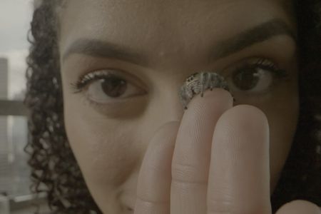 Tiana Gayton looks into the camera while holding Rose the spider on her finger. (Big Wave Productions)