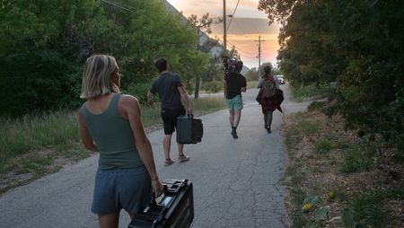 Angel Collinson helps assistant cameraperson Galen Murray, cinematographer Nick Kraus, and production assistant Salaiisa Pili, carry equipment to the next location.(National Geographic/Elena Gaby)