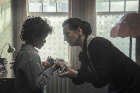 A SMALL LIGHT - Older Alfred Cohen, played by Jasper Thatai, is reunited with his grandmother Mrs. Stoppelman, played by Liza Sadovy, as seen in A SMALL LIGHT. (Credit: National Geographic for Disney/Dusan Martincek)