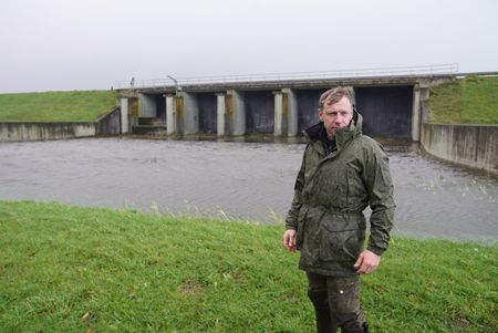 Andy Torbert stands outside a damn on the Ijssel Line. (National Geographic/Ciaran Henry)