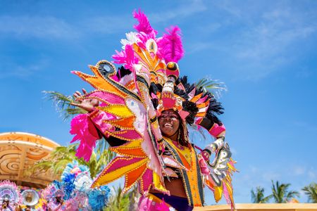 A performer waves while participating in a presentation for guests on Lookout Cay at Lighthouse Point, The Bahamas. (Disney/Steven Diaz)