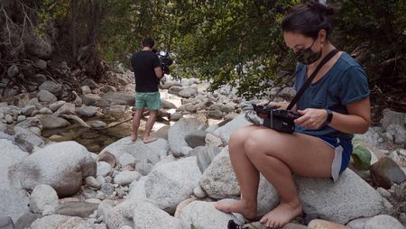 Producer Elena Gaby watches the monitor as cinematographer Nick Kraus films Angel Collinson walking over rocks.  (National Geographic/Galen Murray)