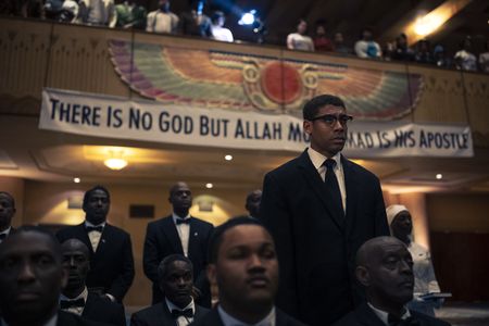 Malcolm X, played by Aaron Pierre, stands during Temple in GENIUS: MLK/X. (National Geographic/Richard DuCree)