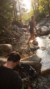 Cinematographer Nick Kraus films Angel Collinson walking down a creek.  (National Geographic/Elena Gaby)