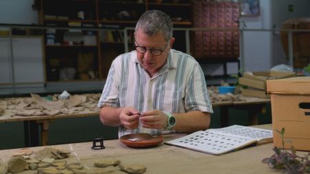 Dr. Guy Steibel documents artifacts in his office in Tel Aviv, Israel. (Windfall Films)