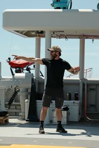 Aldo Kane stands on the deck of the OceanXplorer. (National Geographic/Mario Tadinac)