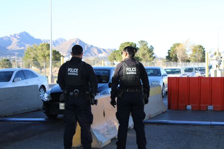 CBP Officers Ybarra and Horta  overlook cars waiting in line in the pre-primary lanes at the El Paso border in El Paso, Texas. (National Geographic)