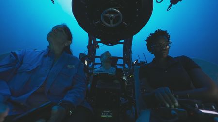 Mithriel Mackay, submersible pilot Buck Taylor & Zoleka Filander descend in one of the OceanXplorer's submersibles on the way down to test the hypothesis that male humpback whales use the topography of the island to acoustically enhance their songs. (National Geographic)