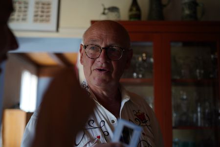 StÈphane Bourgoin shows a crew member his personal 35mm slide collection at his home in France. Bourgoin is a French author and world-renowned specialist on serial killers, who since 2019 has been at the center of an internet-led controversy spearheaded by a group of anonymous true crime fans.  (National Geographic/Ben Selkow)