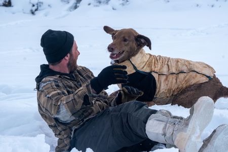 Johnny Rolfe and his dog Java enjoy a moment of playtime in the snow.(BBC Studios Reality Production/Patrick Henderson)