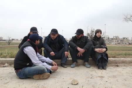 Al Ghouta, Syria - Dr. Amani (R) waits with others during the evacuation. (National Geographic)