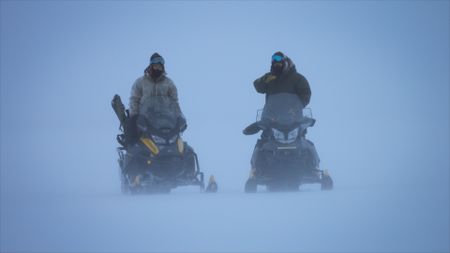 Gage and Avery Hoffman travel on snowmobile through a ground blizzard in the winter. (BBC Studios/Danny Day)