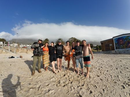 Caleb Swanepoel family and crew on Camps Bay Beach after filming. (National Geographic/Robert Cowling)