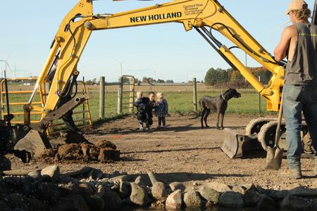 Silas Pol, Beth Pol, Abigail Pol, and their dog Atlas, come to check on the status of the farm's new Pond, while Seth Doble holds a shovel. (National Geographic)