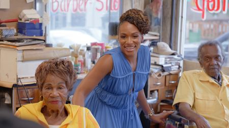 BLACK TRAVEL ACROSS AMERICA - Host Martinique Lewis (Marty) poses for a portrait with Franklin and Maedella Stiger, who have run a barber shop in the Five Points district of Denver, Colo. for over 40 years. (National Geographic for Disney)