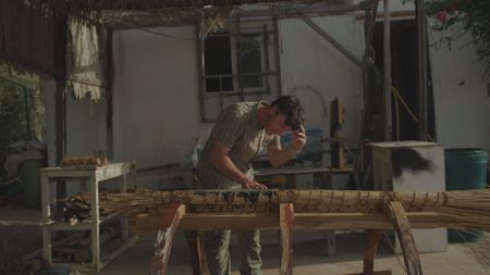 Maritime archaeologist Alessandro Ghidoni examines the beginnings of a reed crafted raft in Qantab, Oman. (Windfall Films)