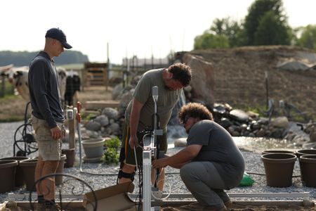 Sam Korthals, Charles Pol, and Andrew Hutton set up the Robot Garden system in the Pol family farm's garden. (National Geographic)