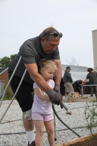 Art Reinhold helps Abigail Pol water plants in the new garden at the Pol family's farm. (National Geographic)