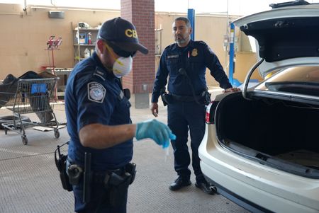 Two CBP officers prepare to dismantle a suspect's vehicle to search for hidden contraband in El Paso, Texas. (National Geographic)