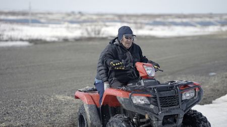 John Pingayak riding a four wheeler through the tundra. (National Geographic/Matt Kynoch)