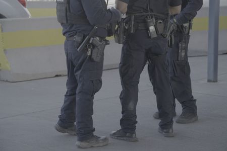 Three CBP officers stand and talk at the El Paso port of entry in El Paso, Texas. (National Geographic)