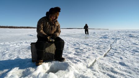 Gage and Avery Hoffman show their cousin how to ice fish. (BBC Studios Reality Productions, LLC/Brian Bitterfeld)