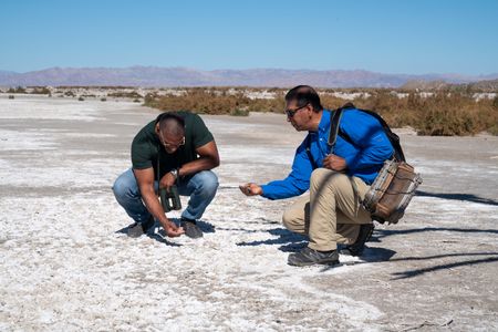 Christian Cooper and Frank Ruiz examine the salty residue ​​at the edge of the Salton Sea in Southern California. Frank explains how the Colorado River used to flood the Salton Basin and when the water ended up in this region, evaporation took its course, leaving the salt behind and making the water saltier. (National Geographic/Jon Kroll)