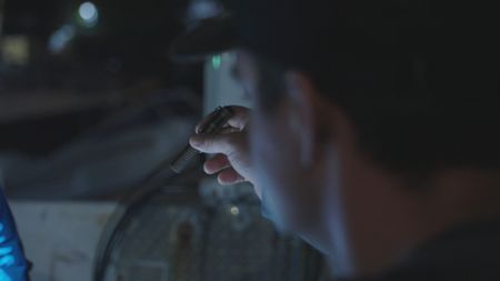 CBP AMO Agent Pete uses a flashlight to inspect a suspect's boat. (Lucky 8 TV/Valery Lyman)